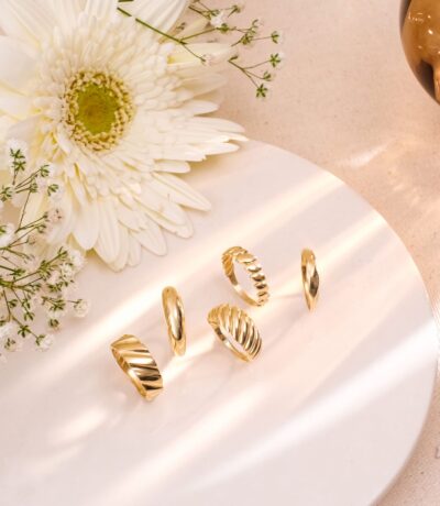Gold rings on a plate with white flower